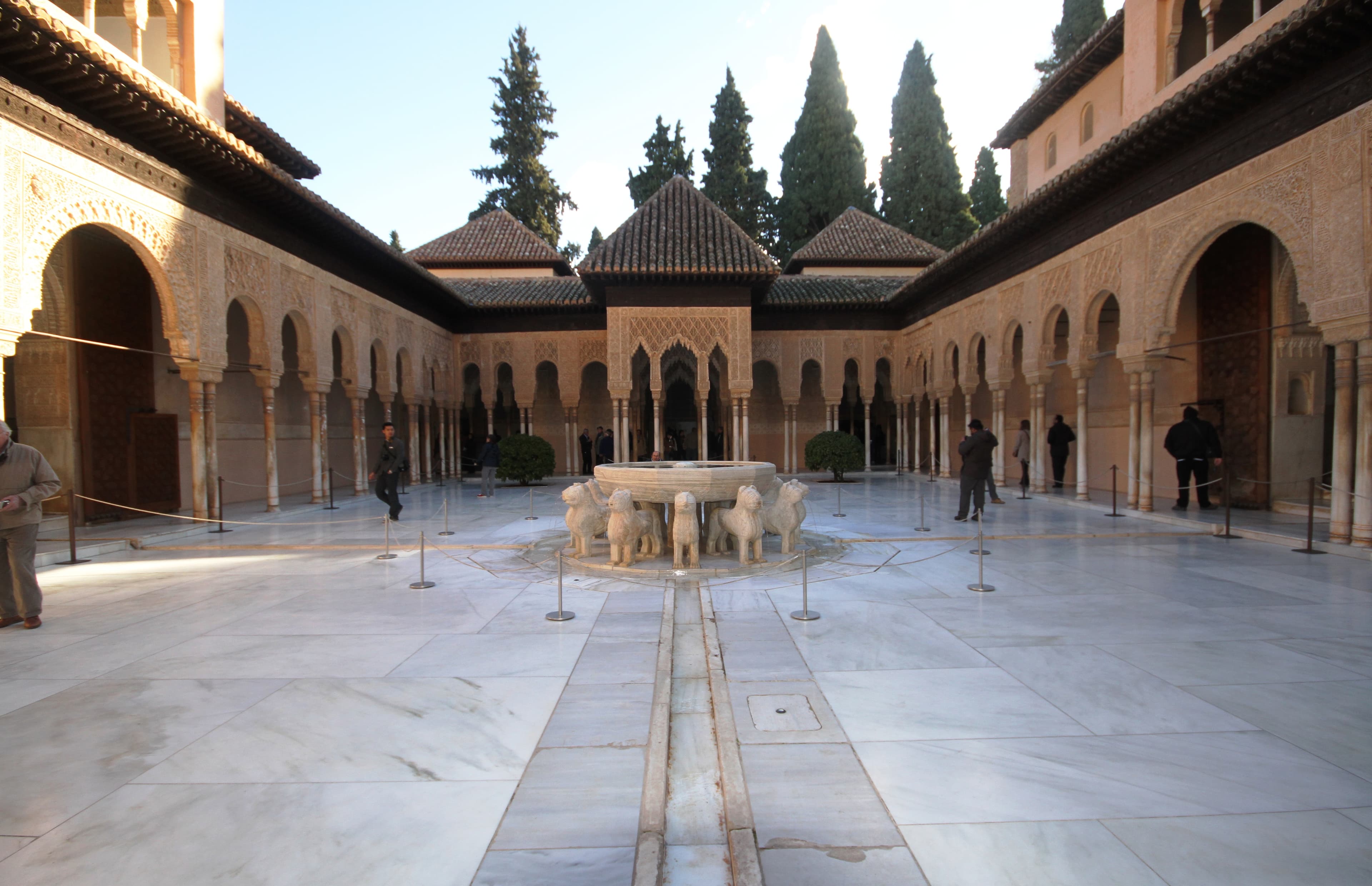 The Patio de los Leones of the Alhambra, with its central fountain surrounded by marble columns and arches of Nasrid lacework.