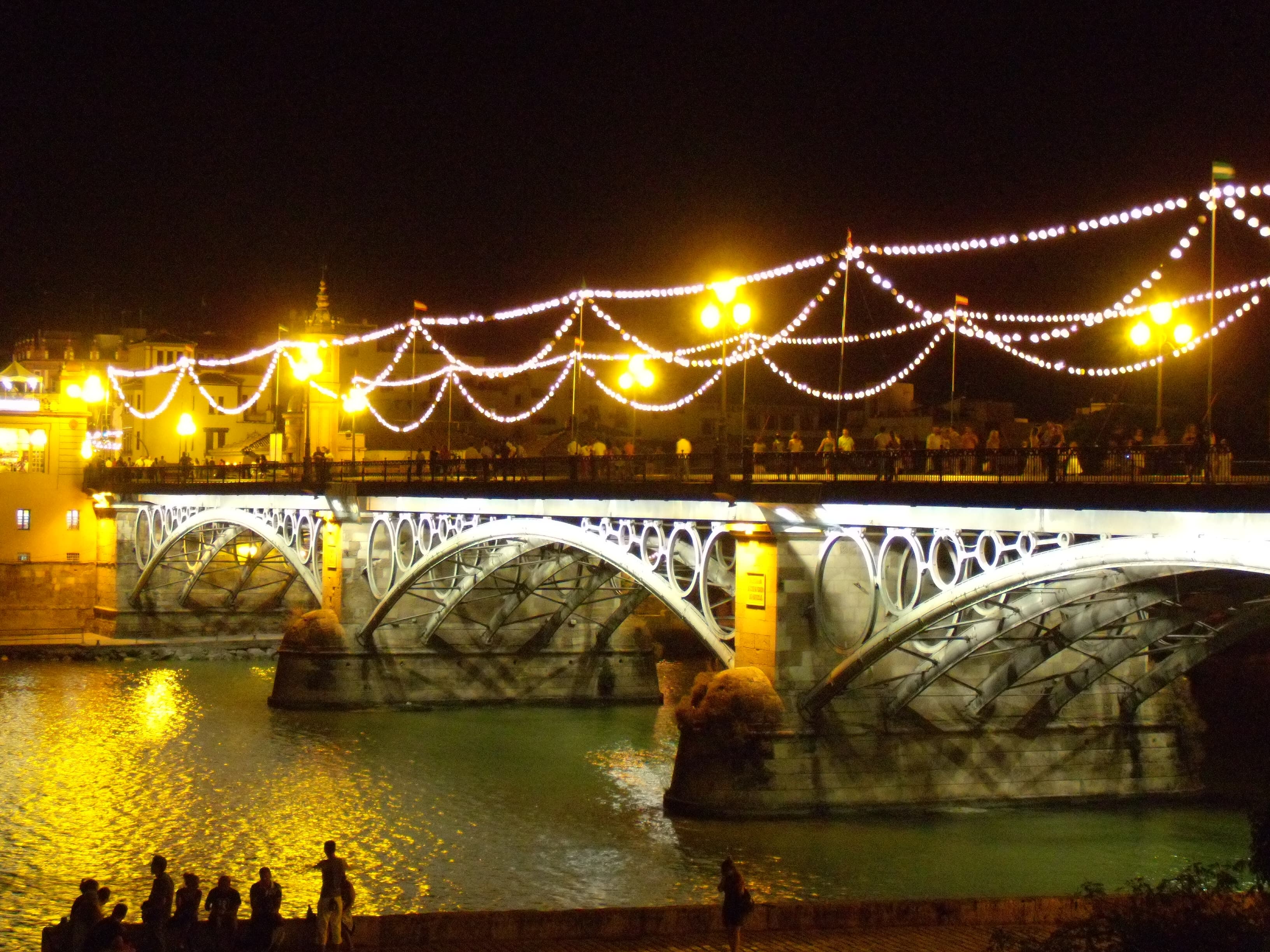 Puente de Triana iluminado durante la Velá de Santa Ana 2008, con el río Guadalquivir al fondo en Sevilla
