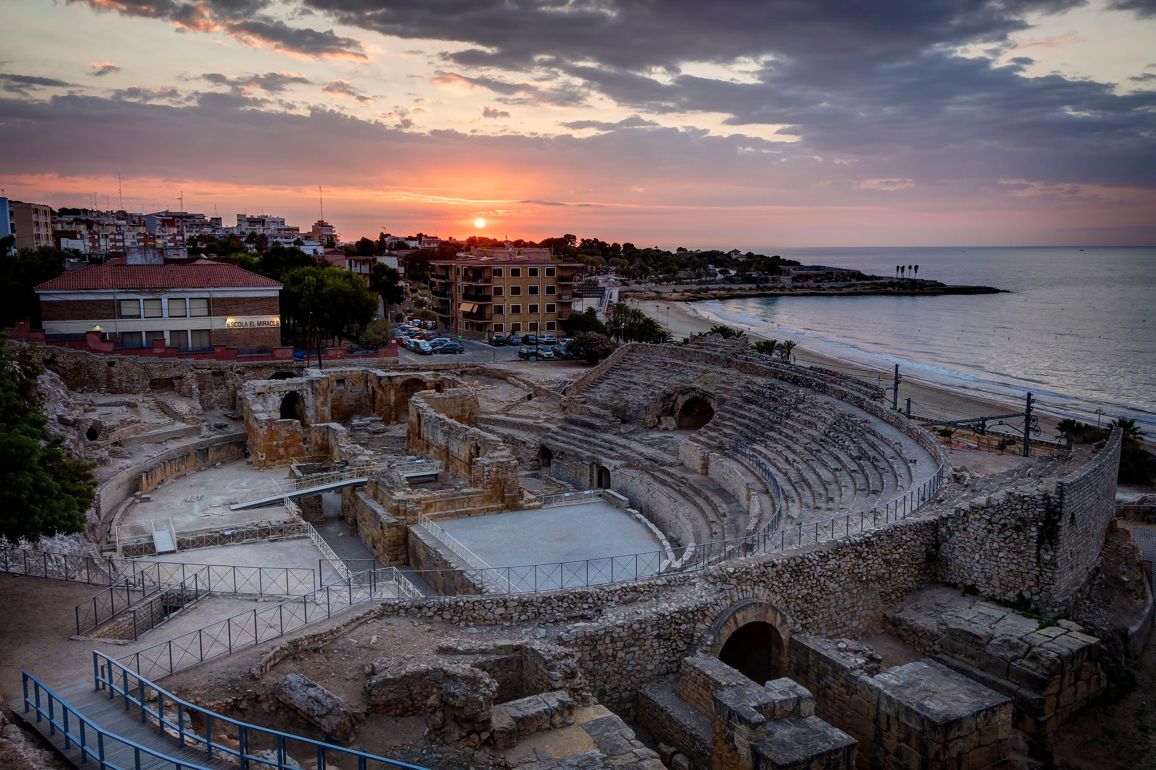 O anfiteatro romano de Tarragona debruçado sobre o mar Mediterrâneo, com as arquibancadas de pedra escavadas em frente à água