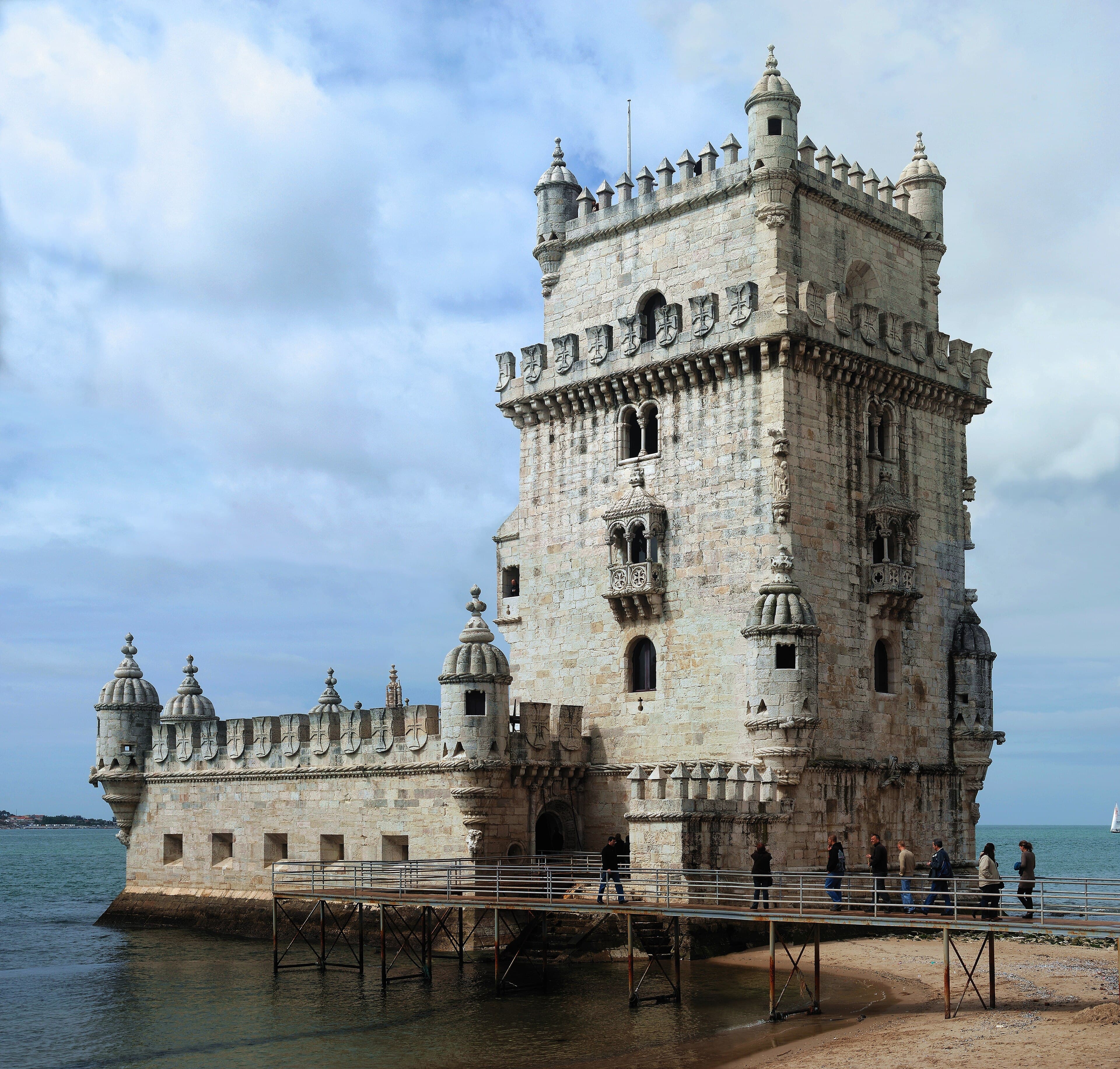 Torre in pietra bianca manuelina che si innalza sull'acqua del Tago sotto un cielo sereno